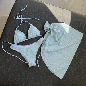 Three-piece light green bikini set with ribbed texture and matching sarong skirt