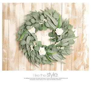 Detail of eucalyptus leaves and white roses on a rustic wood background wreath
