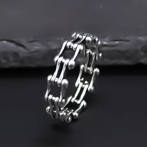 Détail macro d'une bague style chaîne de vélo industrielle avec finition argent mat