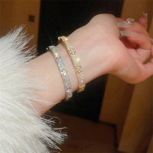 Detailed view of silver and gold zircon flower bracelets showing micro-pave setting