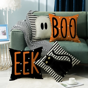 Set of 4 Halloween throw pillow covers with black cat, ghost and stripe patterns on a sofa
