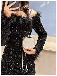Detail of a black sequin dress with feathers and silver octagonal mirrored chain clutch bag