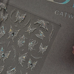 Macro detail of 3D silver laser butterfly nail stickers with pearlescent relief texture