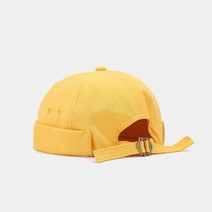 Detail view of bright yellow brimless dock cap showing metal buckle and canvas texture