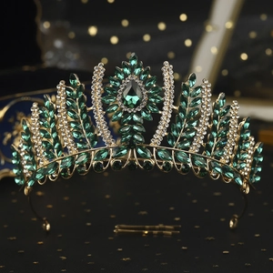 Macro detail of luxury vintage golden bridal crown with emerald green gems and rhinestones