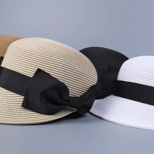 Dettaglio di cappelli di paglia con fiocco nero elegante in vari colori e trama intrecciata