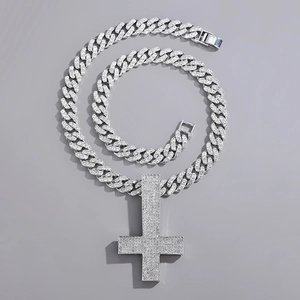 Silver iced out inverted cross pendant with cuban chain shown on a grey background