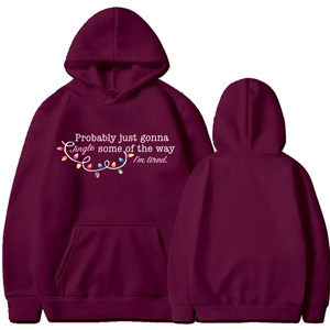 Front and back views of a burgundy Christmas hoodie with festive lights and holiday quote