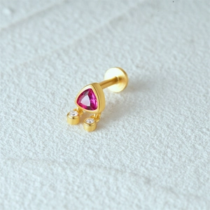 Detail of gold labret stud with triangle rose red gemstone and clear accents