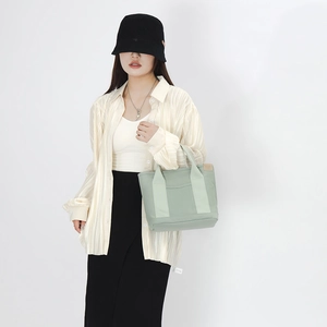 Japanese style light green canvas tote bag shown with model in minimalist outfit