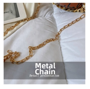 Detail presentation of shiny gold metal chain strap on basketball shaped handbag