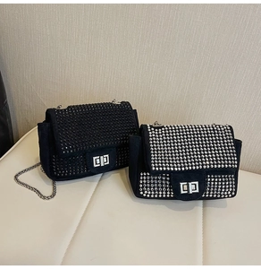 Detail of two black suede crossbody bags with silver metal twist locks and chain straps