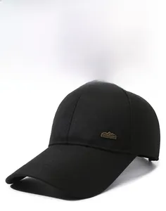 Detailed view of black baseball cap with extended brim and mountain-shaped metal sports tag