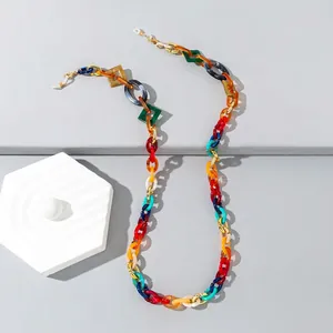 Macro view of multi-color acrylic geometric links and gold fasteners for glasses chain