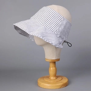 Dettaglio cappello da sole a strisce bianche e nere con coulisse regolabile su manichino