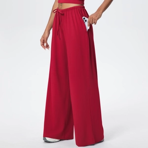 Detail view of red wide-leg sweatpants featuring elastic drawstring waist and side pocket