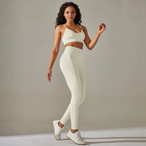 Detailed texture of seamless ribbed knit fabric on cream yoga bra and leggings