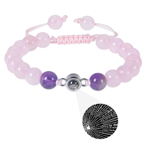 Detailed view of beaded stone bracelet with 100 languages I love you projection charm