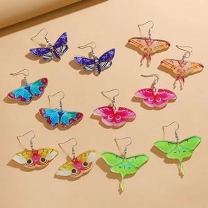 Colorful acrylic butterfly moth earrings collection with gradient wing patterns on beige background