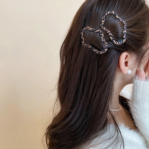 Modella indossa fermagli per capelli leopardati mostrando un profilo elegante con i capelli