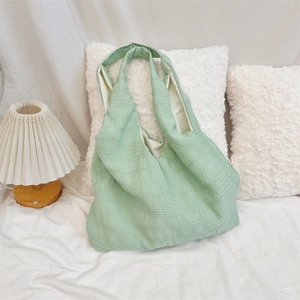 Detail of light green tote bag with crinkle texture and wide shoulder strap