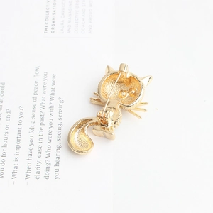 Golden cat brooch back view with durable metal pin closure on minimalist paper