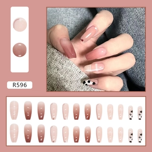 Macro shot of R596 nude and brown gradient press-on nails with cow print and french tips