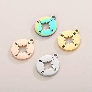 Macro detail of four compass star pendants in rainbow, gold, rose gold and silver colors