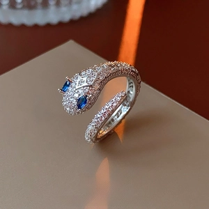 Macro shot of silver snake ring with pavé crystals and blue gemstone eyes detail