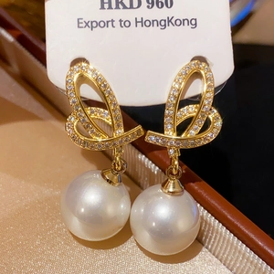 Vintage gold bow earrings with pearls and crystals in a jewelry box for a classic look