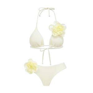 Detail of cream white bikini featuring handmade 3D floral accents on the top and bottom