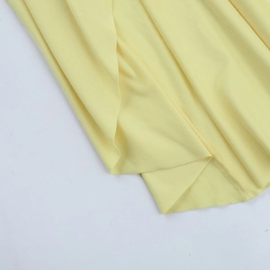 Détail des coutures de précision sur la robe moulante évidée jaune clair à manches