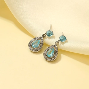 Elegant silver teardrop earrings with light blue gemstone and shimmering diamond halo