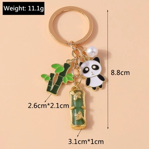 Detail view of panda keychain with bamboo and pearl charms including dimensions and weight