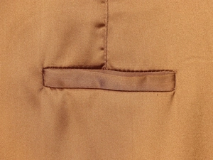 Detailed macro view showing the precise stitching on the pocket of satin wide-leg pants