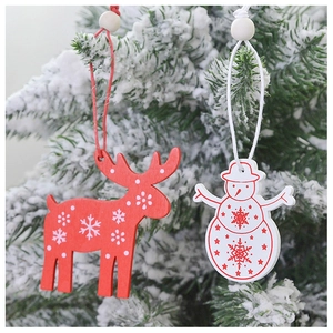 Detail of wooden red elk and white snowman ornaments on a snowy Christmas tree branch