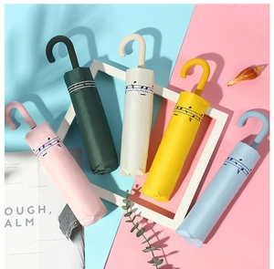 Detail of folding umbrellas in five colors featuring musical notes and a U-shaped handle