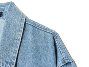 Detalle del cuello polo y costuras del hombro en chaqueta vaquera azul claro