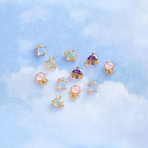 Cartoon space themed earring set with rocket and planet designs in pastel gold plating