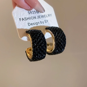 Detail of C-shaped gold earrings with black crystals and S925 silver needle post