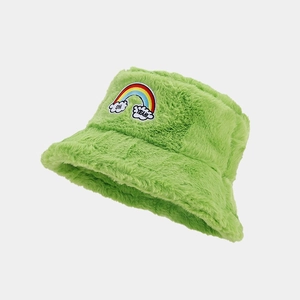 Détail du bob en peluche vert avec broderie arc-en-ciel et texture en fausse fourrure