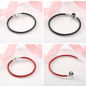 Detail of red and black leather braided bracelets with silver barrel clasp closures