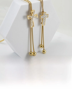 Detailed view of 18K gold plated cross pendant necklace with sparkling white crystals