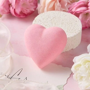 Detailed view of a pink heart-shaped bath bomb in a luxury spa gift set with floral decor