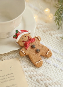 Close-up of resin gingerbread man ornament with red hat on a warm festive background