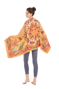 Detail view of large bohemian beach towel featuring vibrant sun and floral tapestry patterns