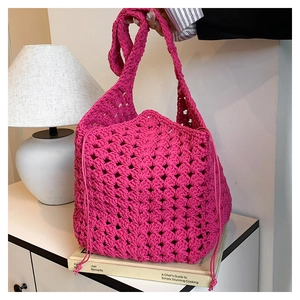 Dettaglio della borsa a secchiello fucsia all'uncinetto con trama traforata e coulisse