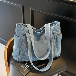 Washed blue denim tote bag with multiple pockets and large capacity for casual style