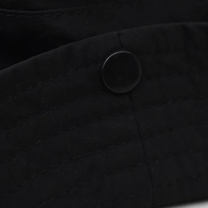 Detail of durable black outdoor hat featuring reinforced stitching and a plastic snap button