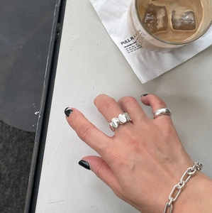Close-up of irregular 925 sterling silver ring and chain bracelet on a hand